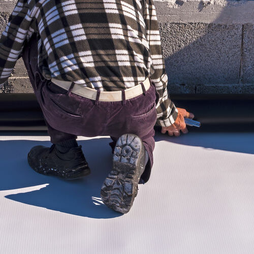 Roofer Installing Single Ply Roofing on Commercial Building